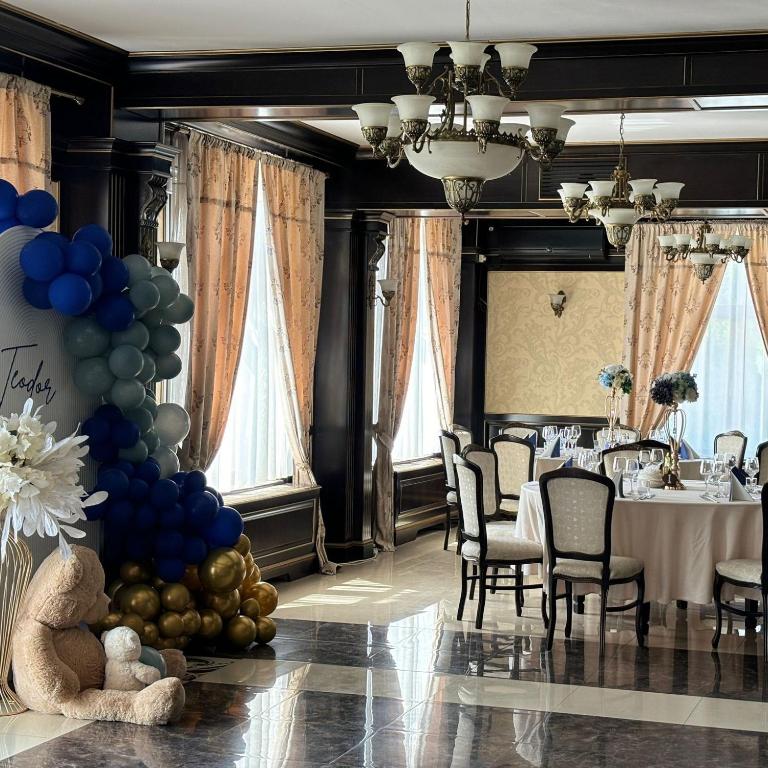 Decor cu baloane albastre si aurii pentru botez, langa o masa festiva